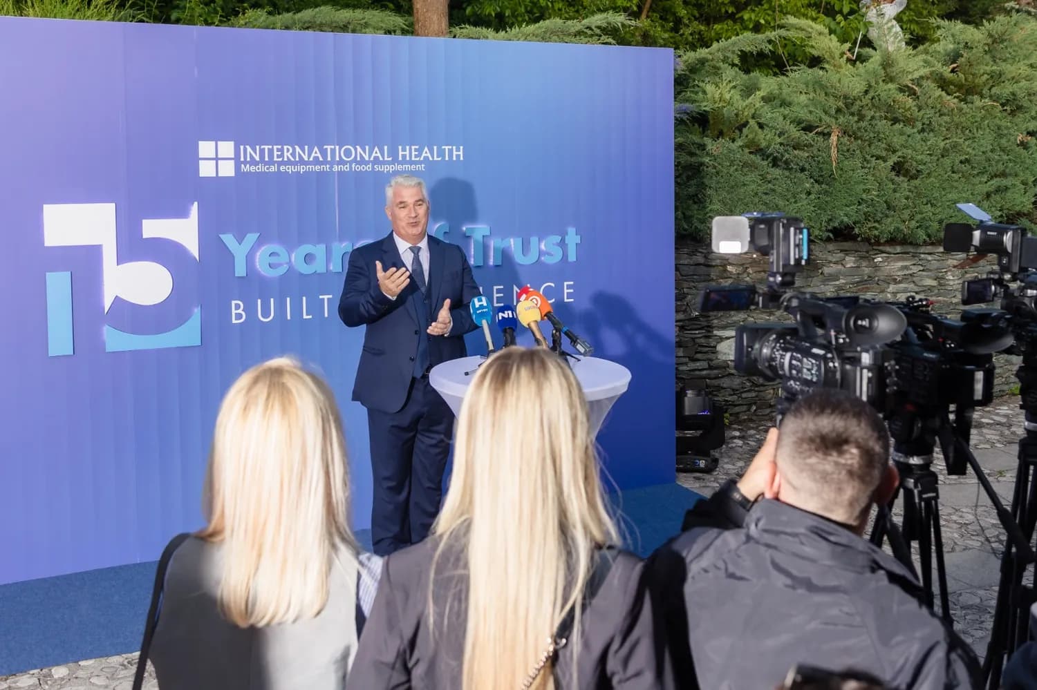 Ivan Vajs na pozornici "15 Years of Trust" , okruzen mdeijima i kamerama